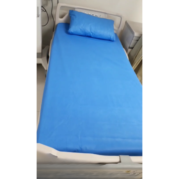 Non-woven disposable bedsheet and pillow cover fitted on a hospital bed.