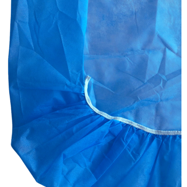 Closeup of elastic fitting and non-woven fabric texture of disposable hospital bedsheet.