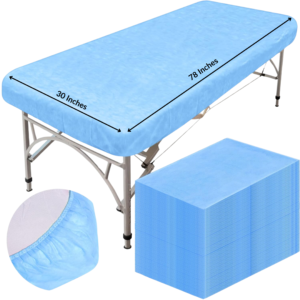 Blue non-woven disposable fitted couch sheet with elastic corners on examination couch and stack of sheets.